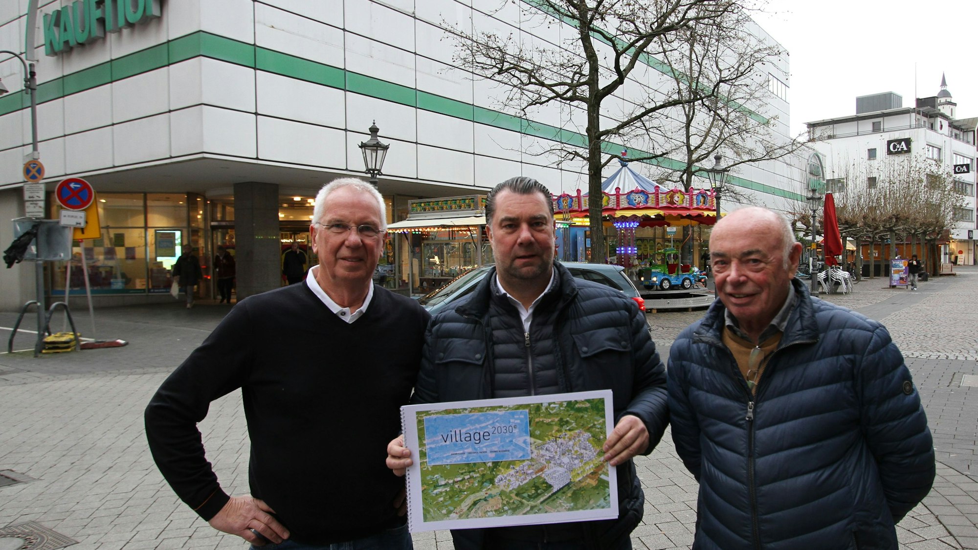 Drei Männer mit einer großen Broschüre vor einem Warenhaus