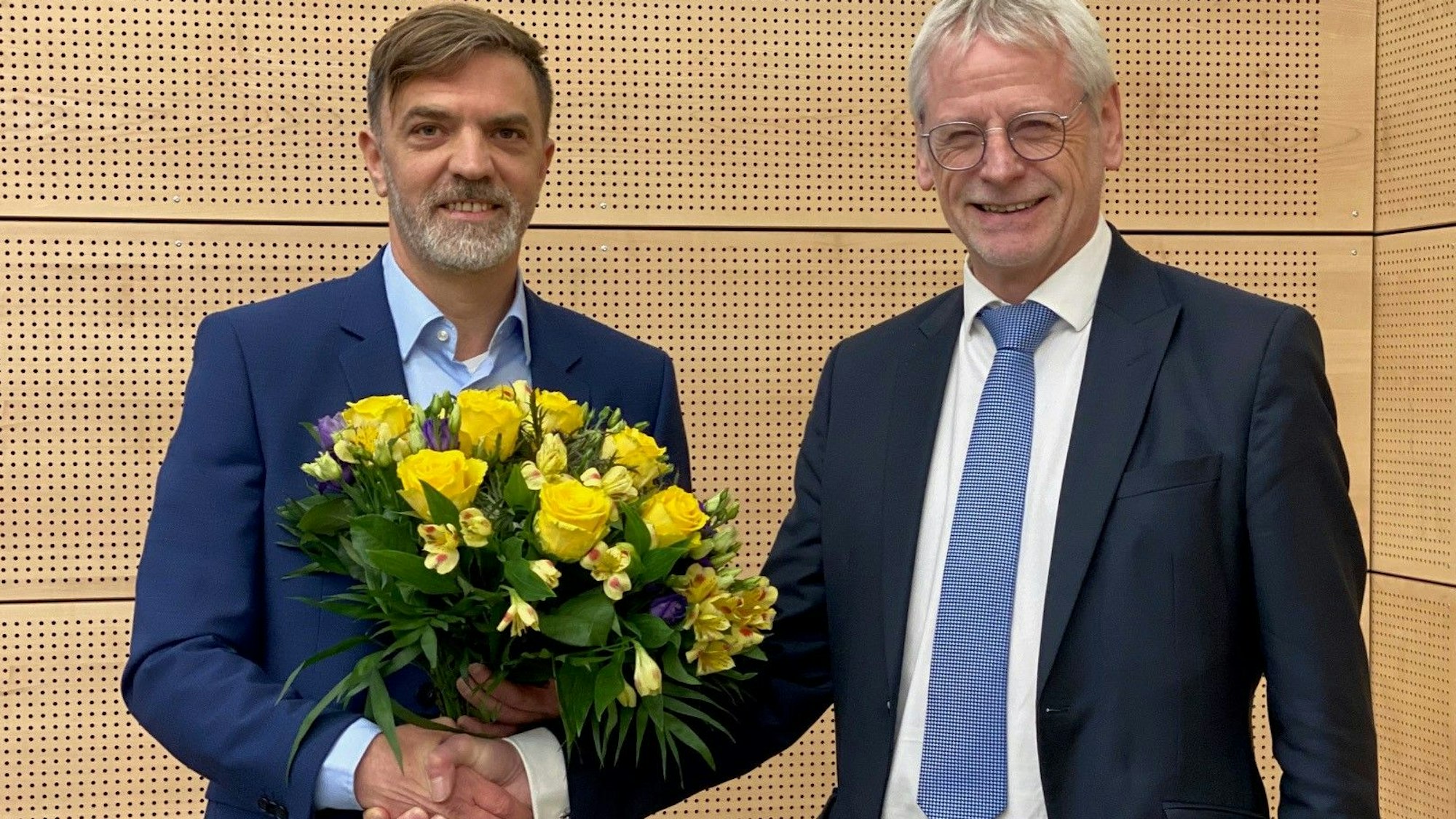 Das Bild zeigt Gerno Böll, frischgewählter Dezernent, wie er von Bürgermeister Dieter Freytag einen Blumenstrauß erhält.