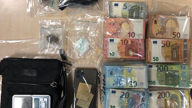 Bargeld in Tüten, ein Handy, und Drogenpäckchen liegen auf einem Tisch