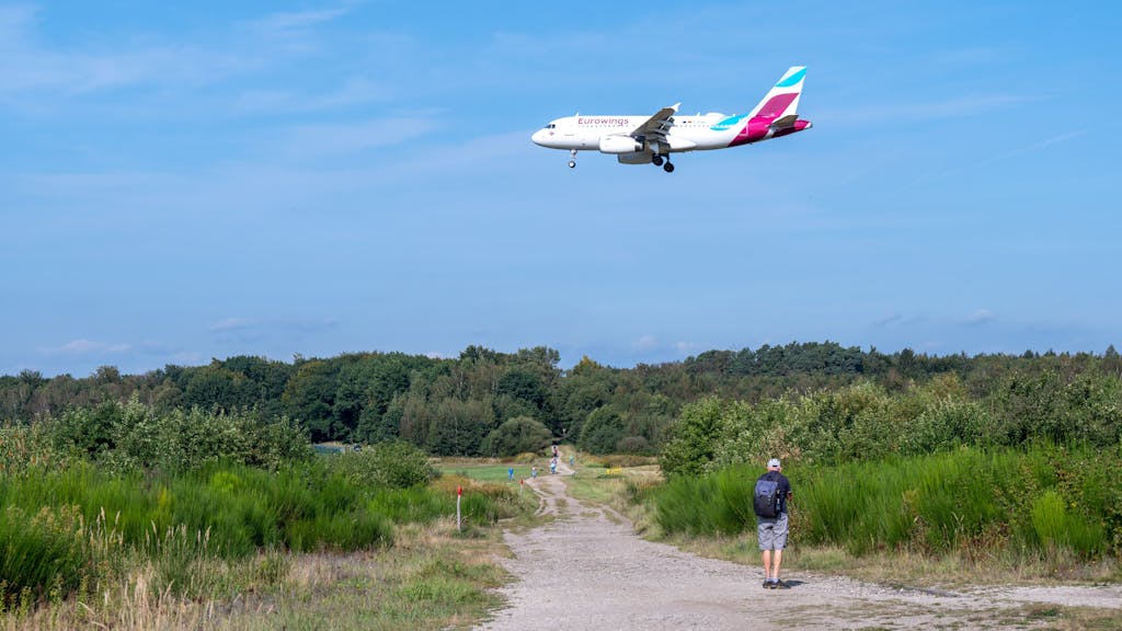 Flugzeug von Eurowings fliegt über das Naturschutzgebiet Wahner Heide.