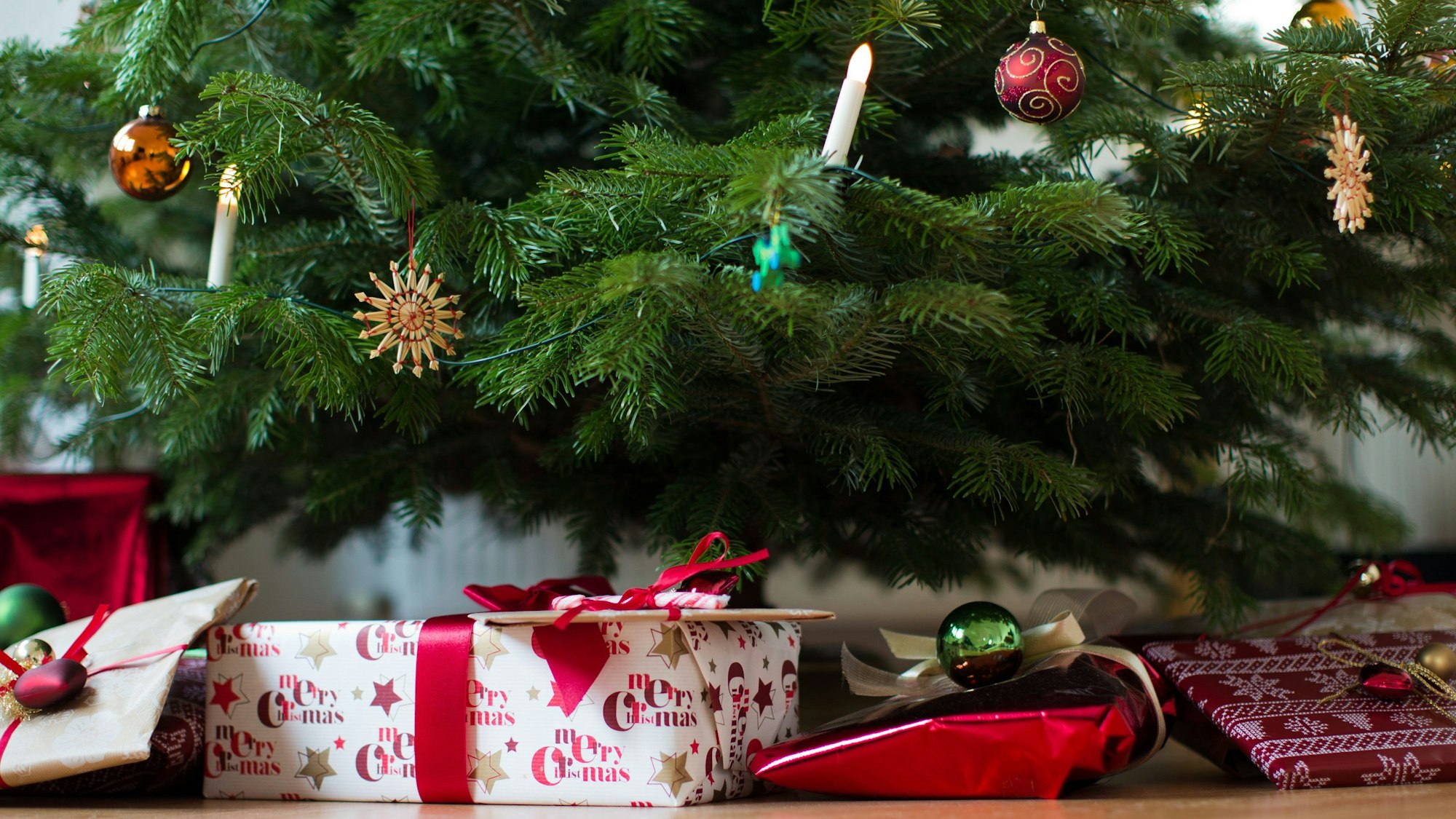 Geschenke liegen unter einem geschmückten Weihnachtsbaum.