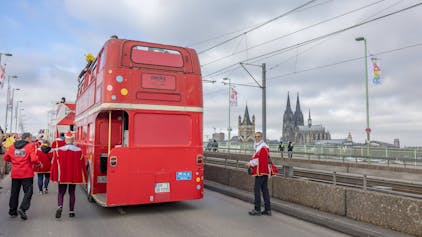 Roter Doppeldecker-Bus beim Rosenmontagszug auf der Deutzer Brücke.