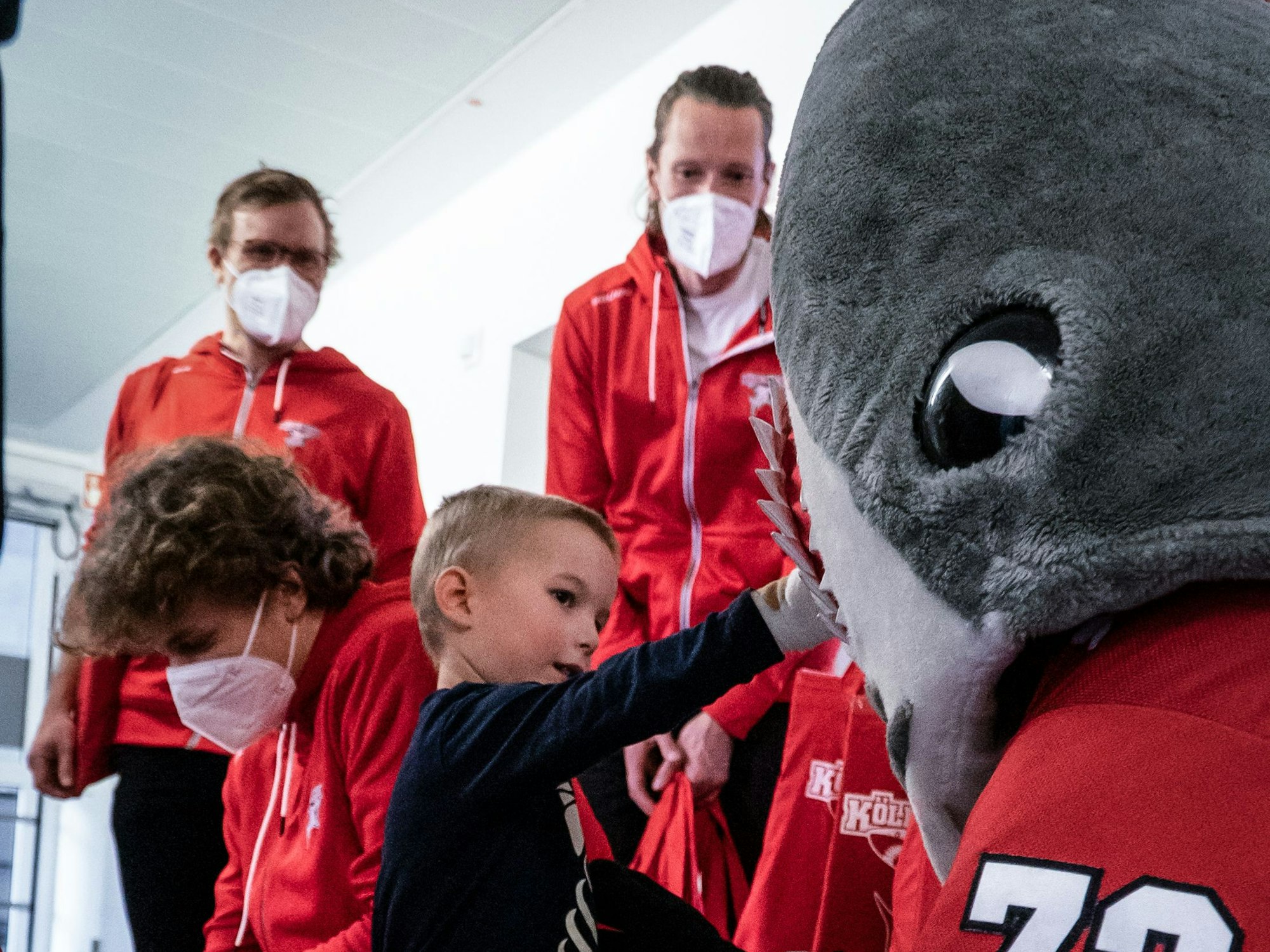 Ein junger Patient freut sich riesig über den Besuch von Haie-Maskottchen Sharky im Kinderkrankenhaus Amsterdamer Straße.