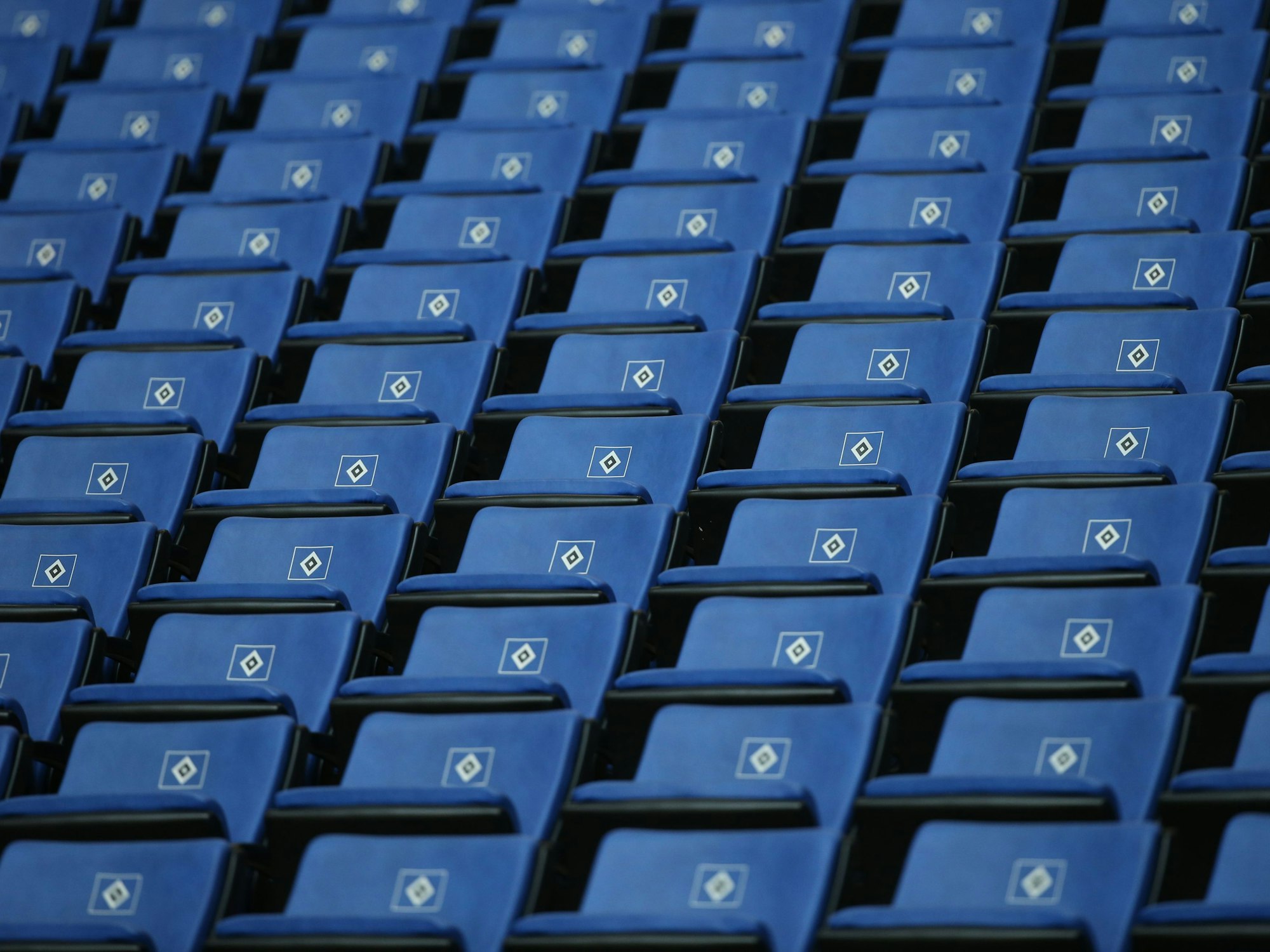 Leere Tribünensitze mit dem Logo des Hamburger SV sind vor dem Spiel auf der Tribüne zu sehen.