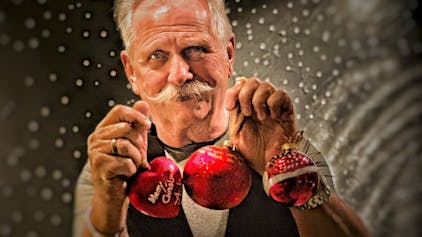 Henning Krautmacher hält selbst gestaltete Weihnachtskugeln.