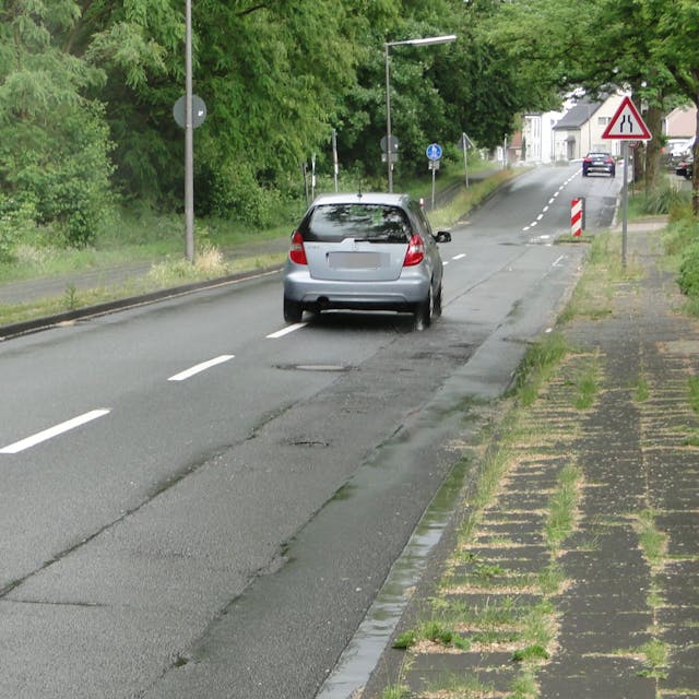 Die Bruchstraße ist stark frequentiert, was am Asphalt seine Spuren hinterlassen Eine Straße mit deutlichen Schäden ist zu sehen.