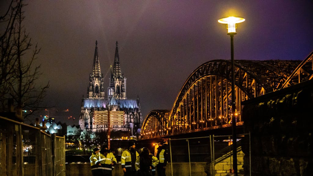 Die Hohenzollernbrücke ist seitlich zu sehen. Im Hintergrund steht der Kölner Dom.