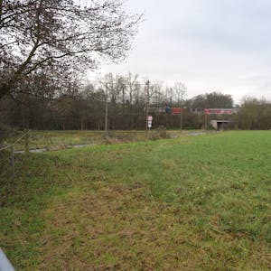 Auf einer Freifläche an der Brander Straße (l.) will die Stadt Rösrath Wohncontainer für Geflüchtete aufstellen. Sie grenzt direkt an die Autbahn A3 (im Hintergrund).
