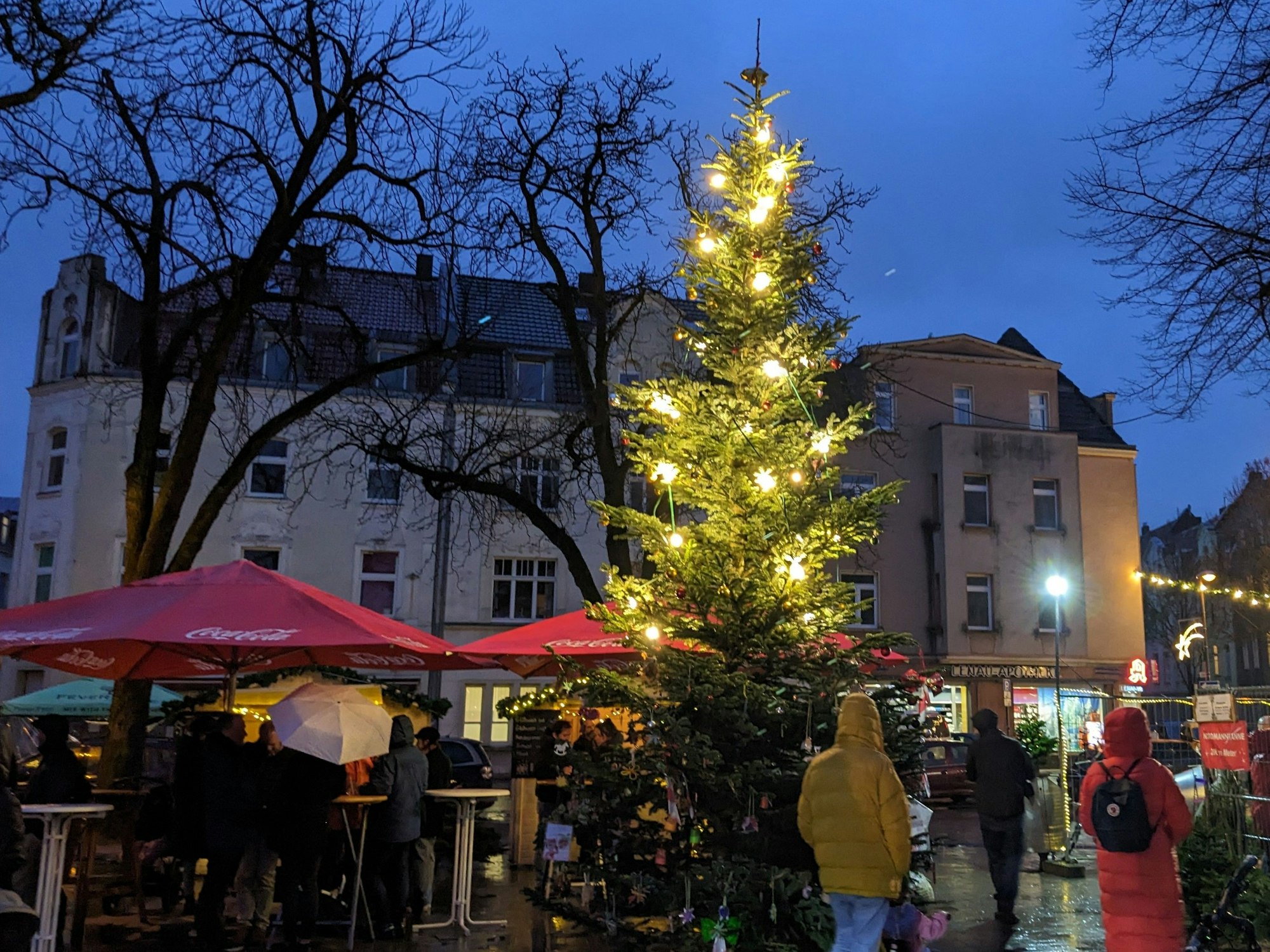 Der Weihnachtsmarkt in Neuehrenfeld: In der Mitte des Lenauplatzes steht ein großer Tannenbaum.