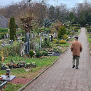 Ein Mann geht über einen Friedhof.