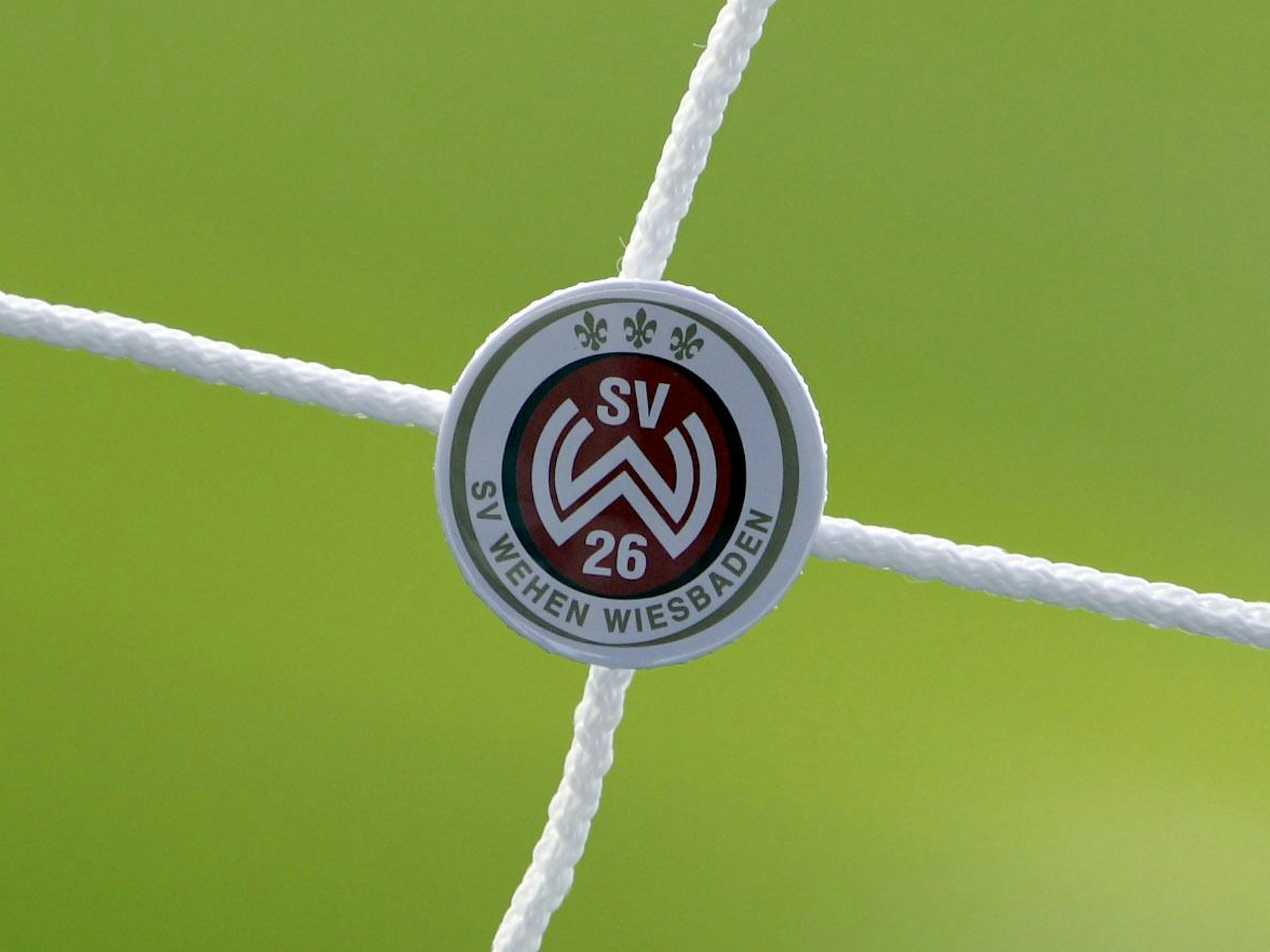 Ein Ansteckbutton des SV Wehen Wiesbaden hängt an einem Tornetz im Fußballstadion des Zweitligisten SV Wehen Wiesbaden.