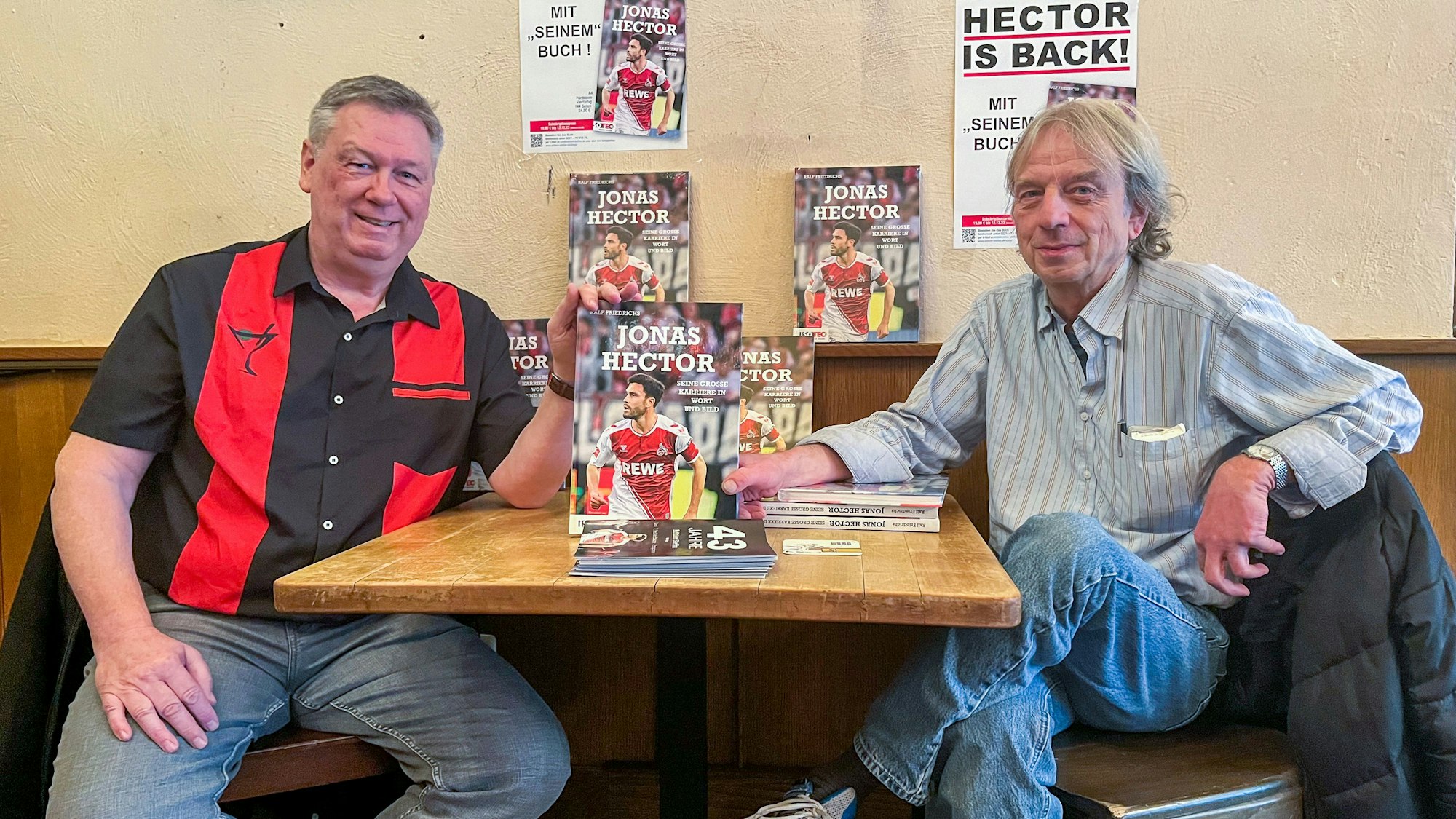 Ralf Friedrichs und Frank Steffan halten das Buch „Jonas Hector – Seine große Karriere in Wort und Bild“ zwischen sich.