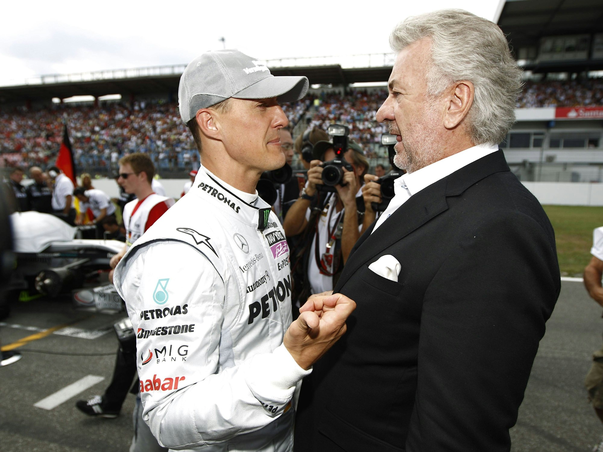 Michael Schumacher und Willi Weber unterhalten sich auf der Rennstrecke.