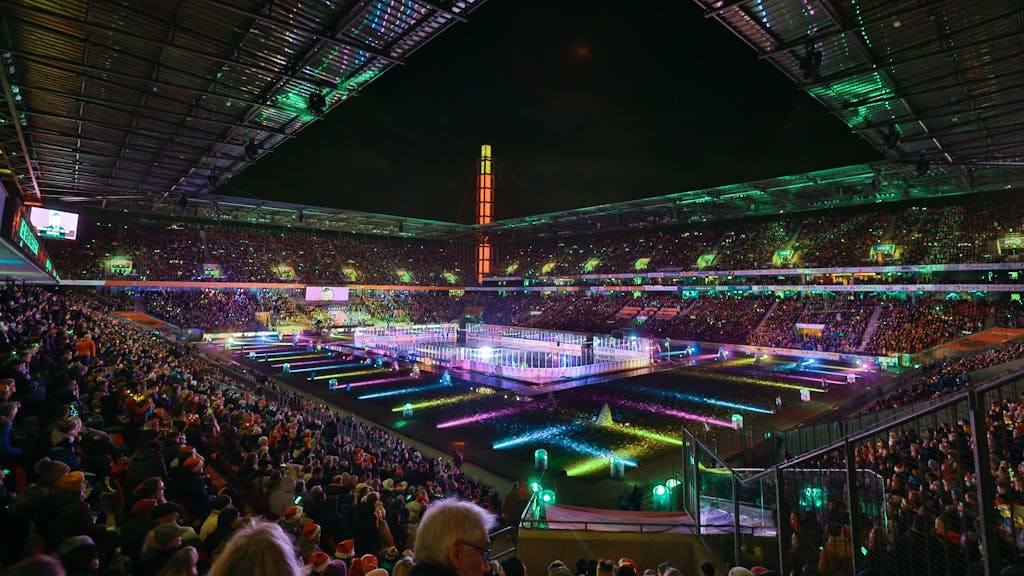 Blick ins Rhein-Energie-Stadion in Köln, das für ein Mitsingkonzert hell und bunt erleuchtet ist.