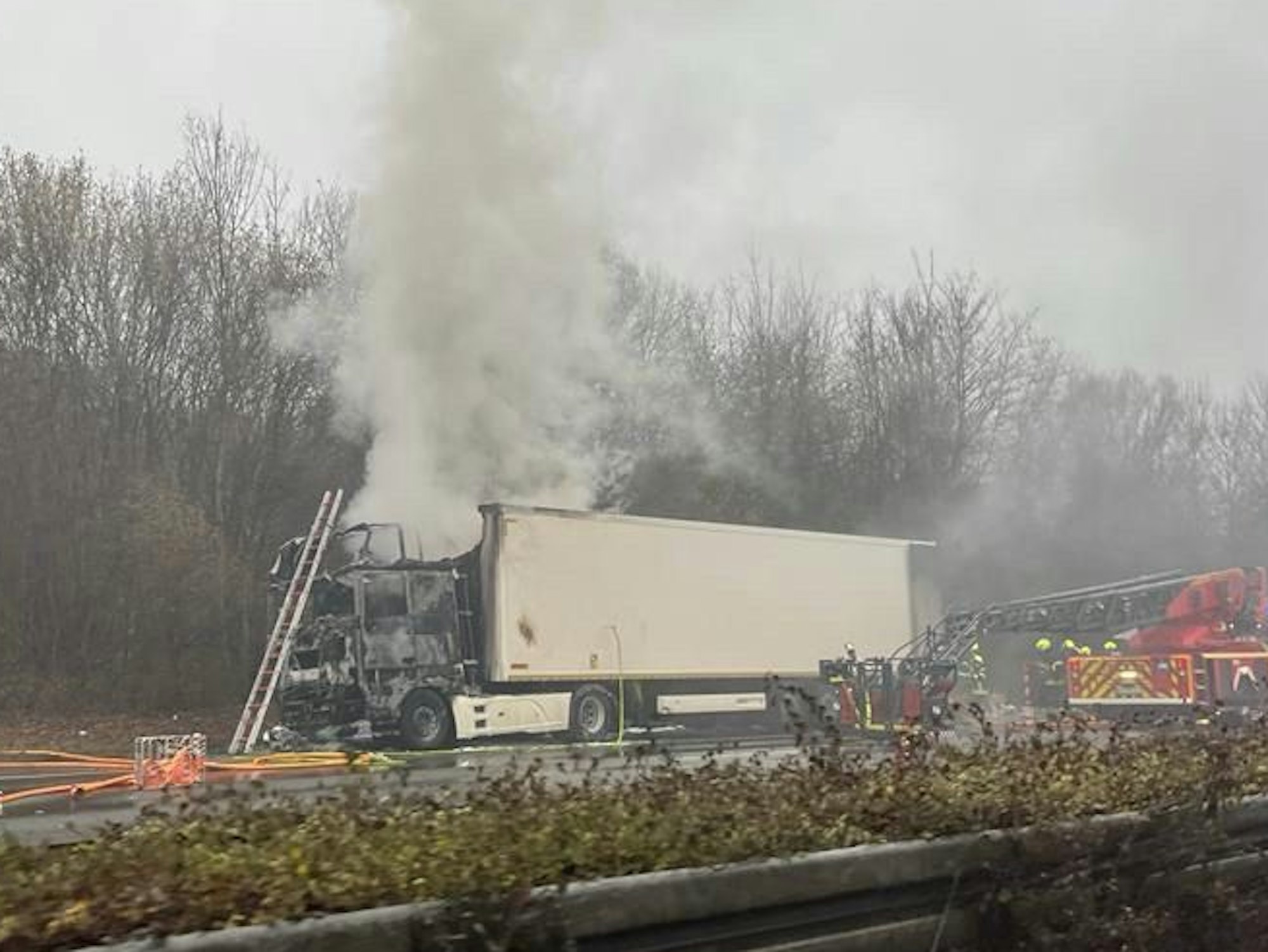 Ein verbrannter Lastwagen steht am Fahrbahnrand einer Autobahn.