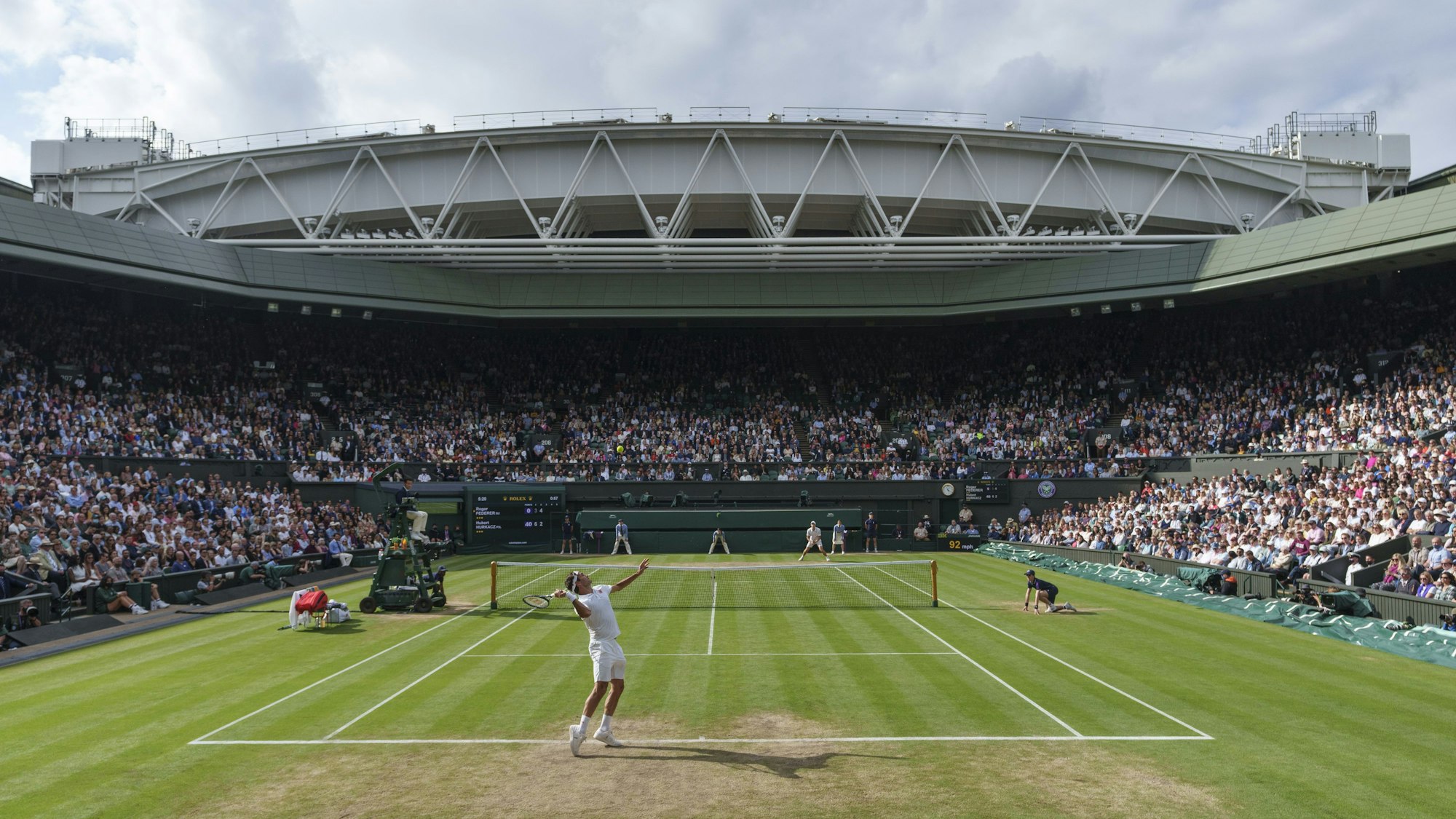 Roger Federer (vorne) schlägt auf dem Centre Court auf.