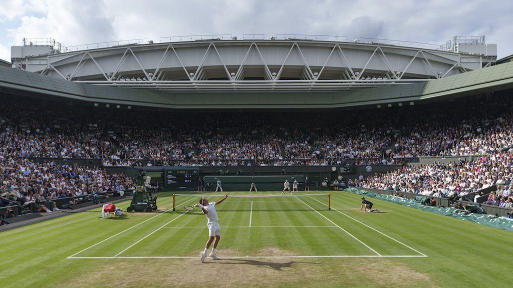 Roger Federer (vorne) schlägt auf dem Centre Court auf.