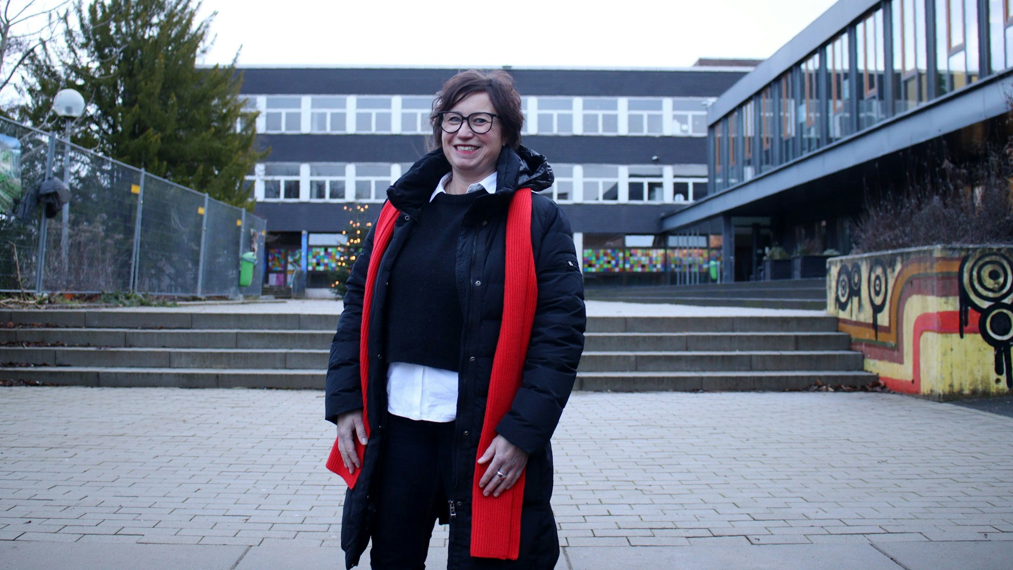 Alexandra Kühne, stellvertretende Vorsitzende der Schulpflegschaft, steht lächelnd auf dem Schulhof des St.-Angela-Gymnasiums.