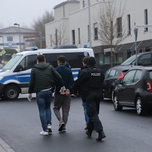 Die Polizei führt bei der Razzia in Hennef einen Verdächtigen ab.