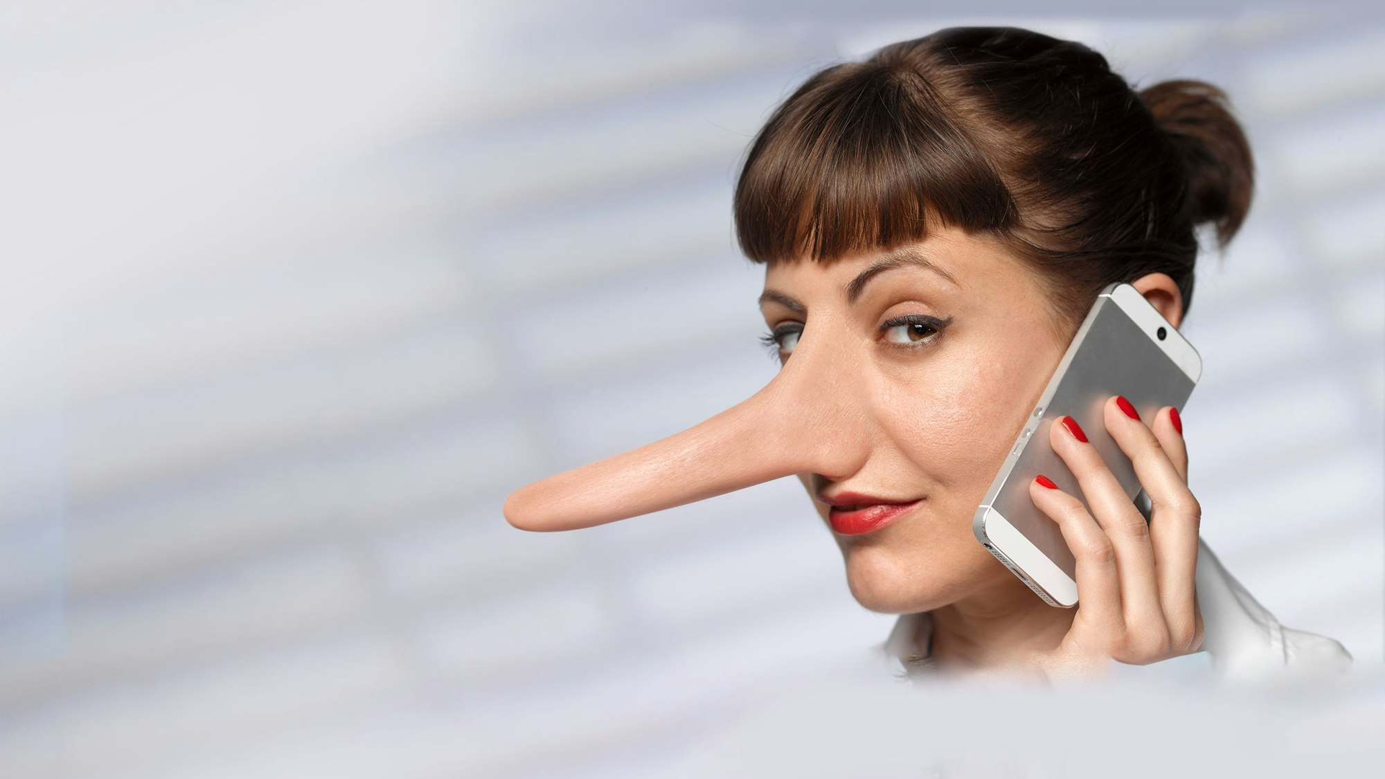 Eine Frau mit einer langen Nase telefoniert mit einem Mobiltelefon.