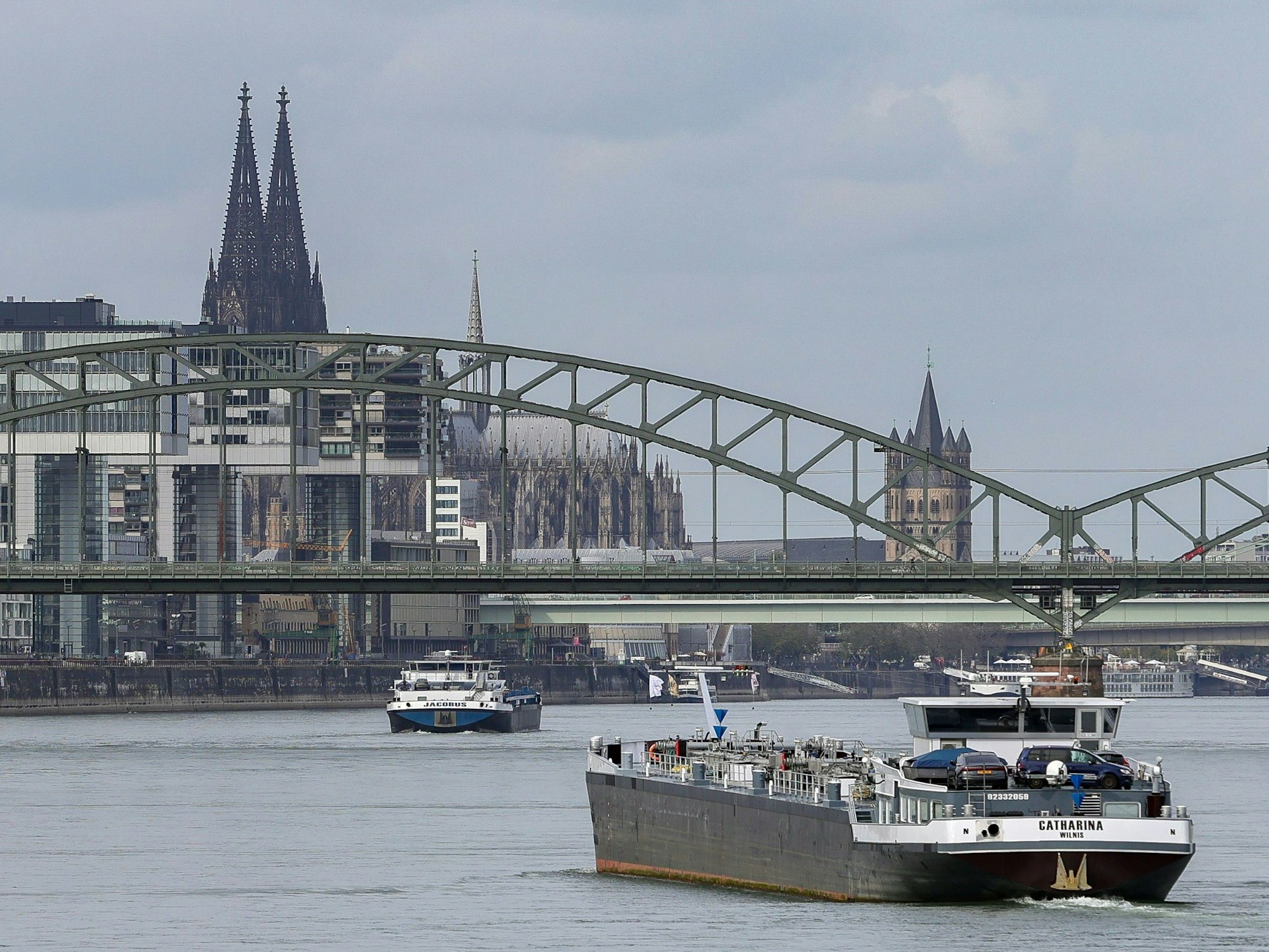 Ein Frachtschiff auf dem Rhein bei Köln. Im Hintergrund ist der Kölner Dom zu sehen.