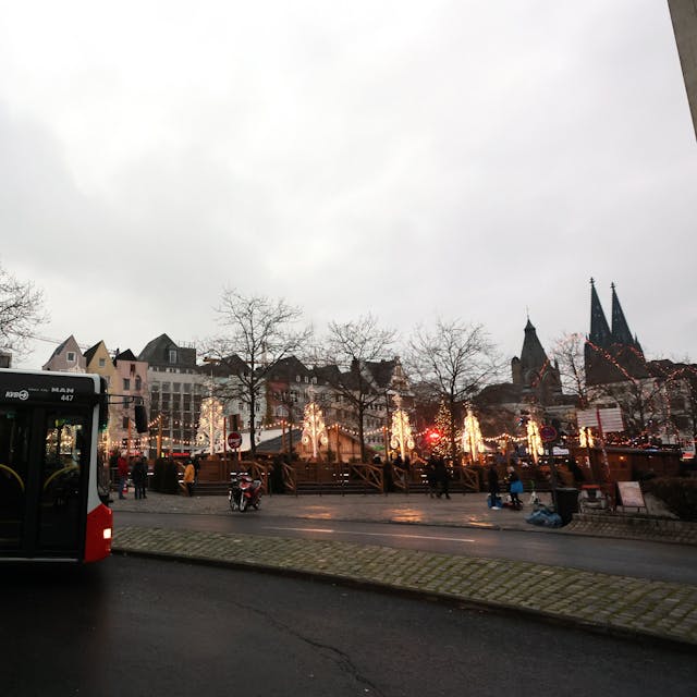 Der Weihnachtsmarkt-Shuttle der KVB fährt Touristen vom Heumarkt zurück zu ihren Reisebussen in Deutz. Im Hintergrund: Warme Lichter vom Kölner Weihnachtsmarkt.