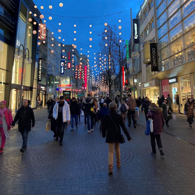 Das Bild zeigt eine Fußgängerzone mit Weihnachtsbeleuchtung.