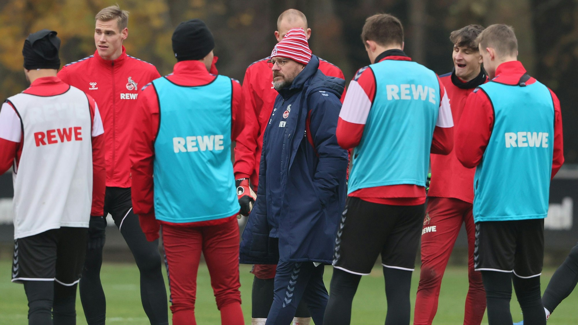 Steffen Baumgart steht beim Training des 1. FC Köln im Kreise seiner Spieler.
