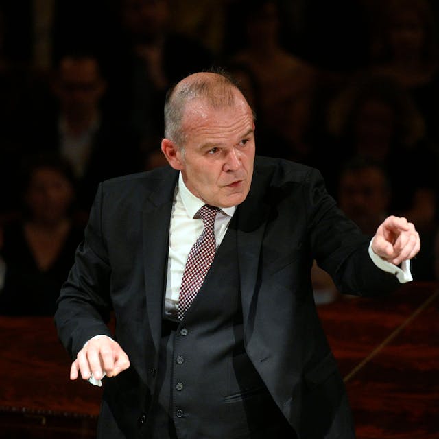 François-Xavier Roth dirigiert im dreiteiligen Anzug mit Krawatte.
