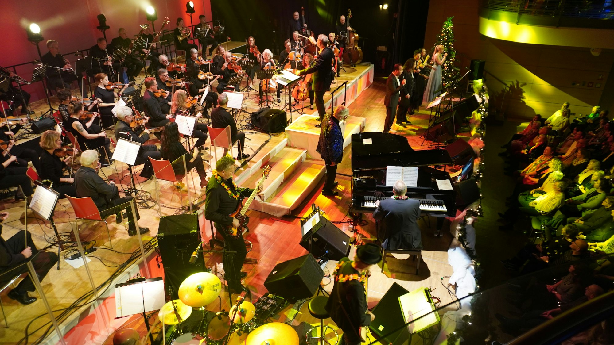 Eine Bühne mit klassischen Orchestermusikern und einer Band.