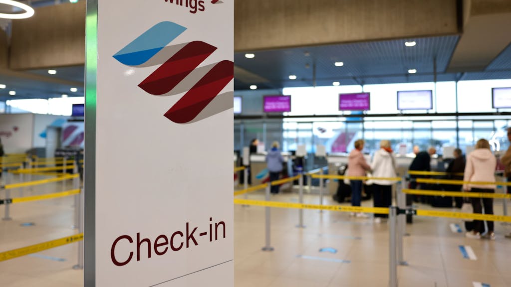 Reisende am Flughafen Köln/Bonn stehen in der Abflughalle an den Check-in-Schaltern der Airline Eurowings, hier im Oktober 2022.&nbsp;