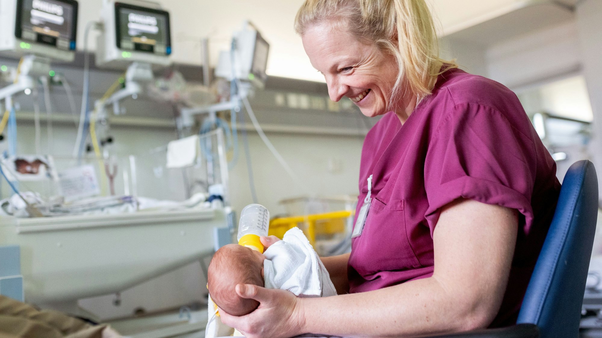 Kinderkrankenpflegerin Kathrin Kartal gibt einem Baby die Flasche.
