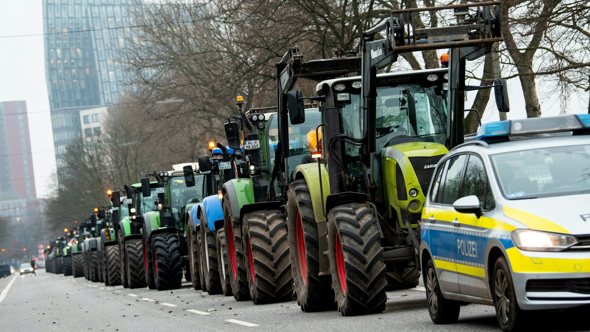Landwirte stehen mit Traktoren in der Hamburger Innenstadt und protestieren gegen die von der Ampel-Koalition geplante Streichung von Steuervergünstigungen für die Landwirtschaft. Im Hintergrund sind die Tanzenden Türme zu sehen.