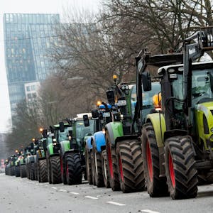 Landwirte stehen mit Traktoren in der Hamburger Innenstadt und protestieren gegen die von der Ampel-Koalition geplante Streichung von Steuervergünstigungen für die Landwirtschaft. Im Hintergrund sind die Tanzenden Türme zu sehen.