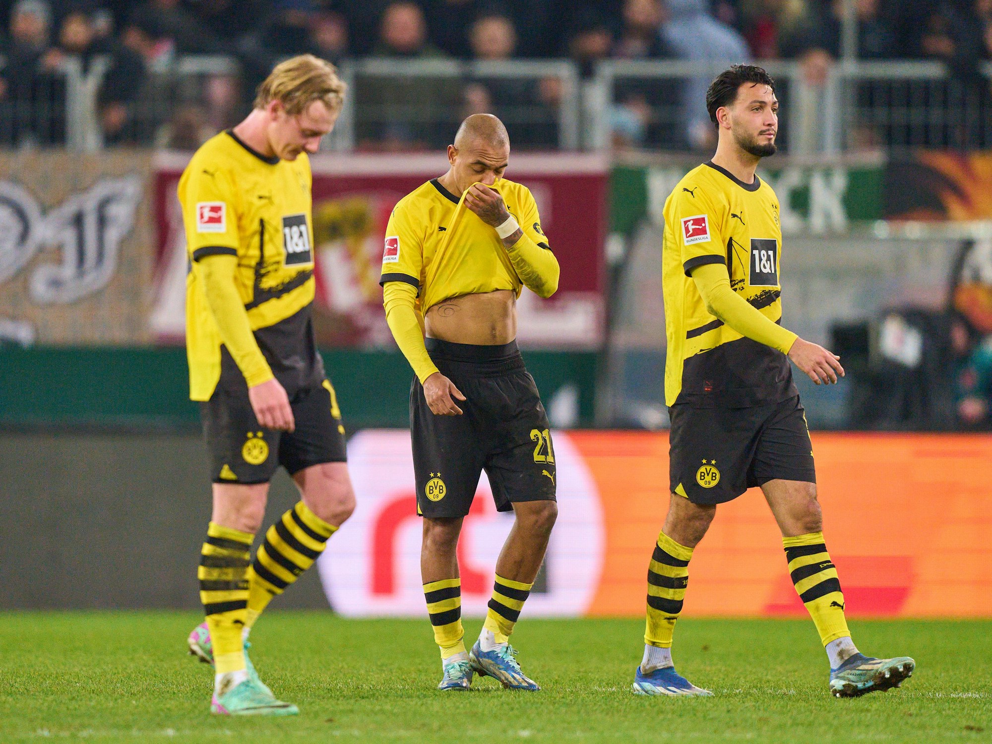 Die BVB-Profis Julian Brandt (l.), Donyell Malen (M.) und Ramy Bensebaini nach dem enttäuschenden Auftritt gegen Augsburg am Samstag (16. Dezember 2023).