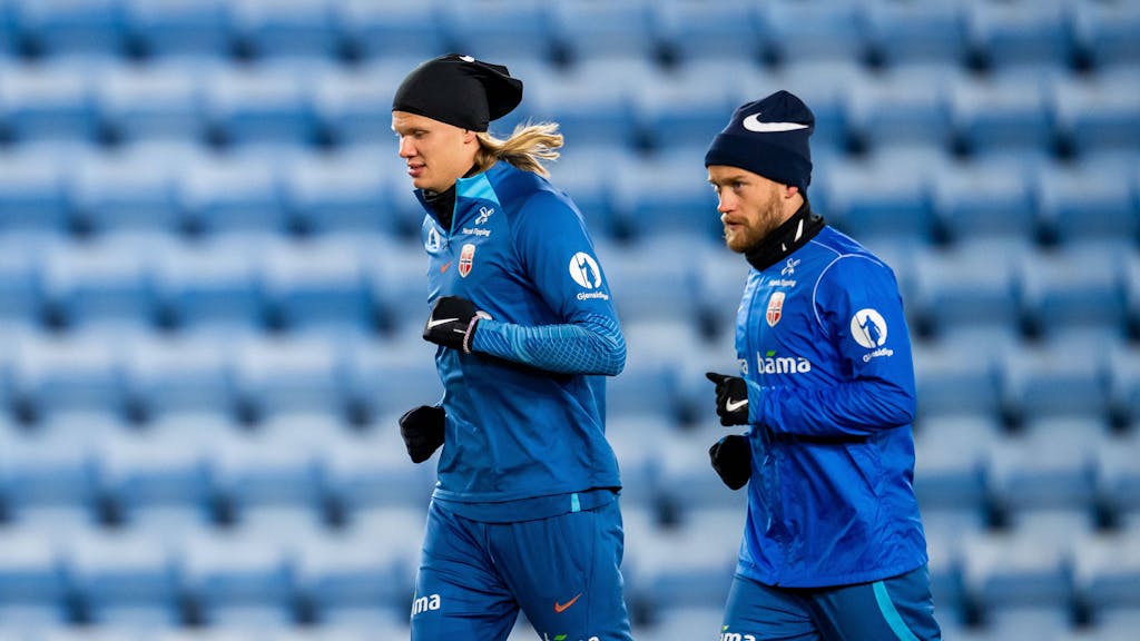 Bard Finne (r.) läuft beim Training der norwegischen Nationalmannschaft neben Superstar Erling Haaland. Beide tragen Handschuhe und eine Mütze.