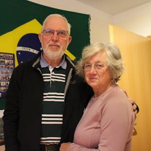 Krista und Walter Feckinghaus stehen vor einer Brasilien-Flagge in seinem Arbeitszimmer in Oberwichterich.
