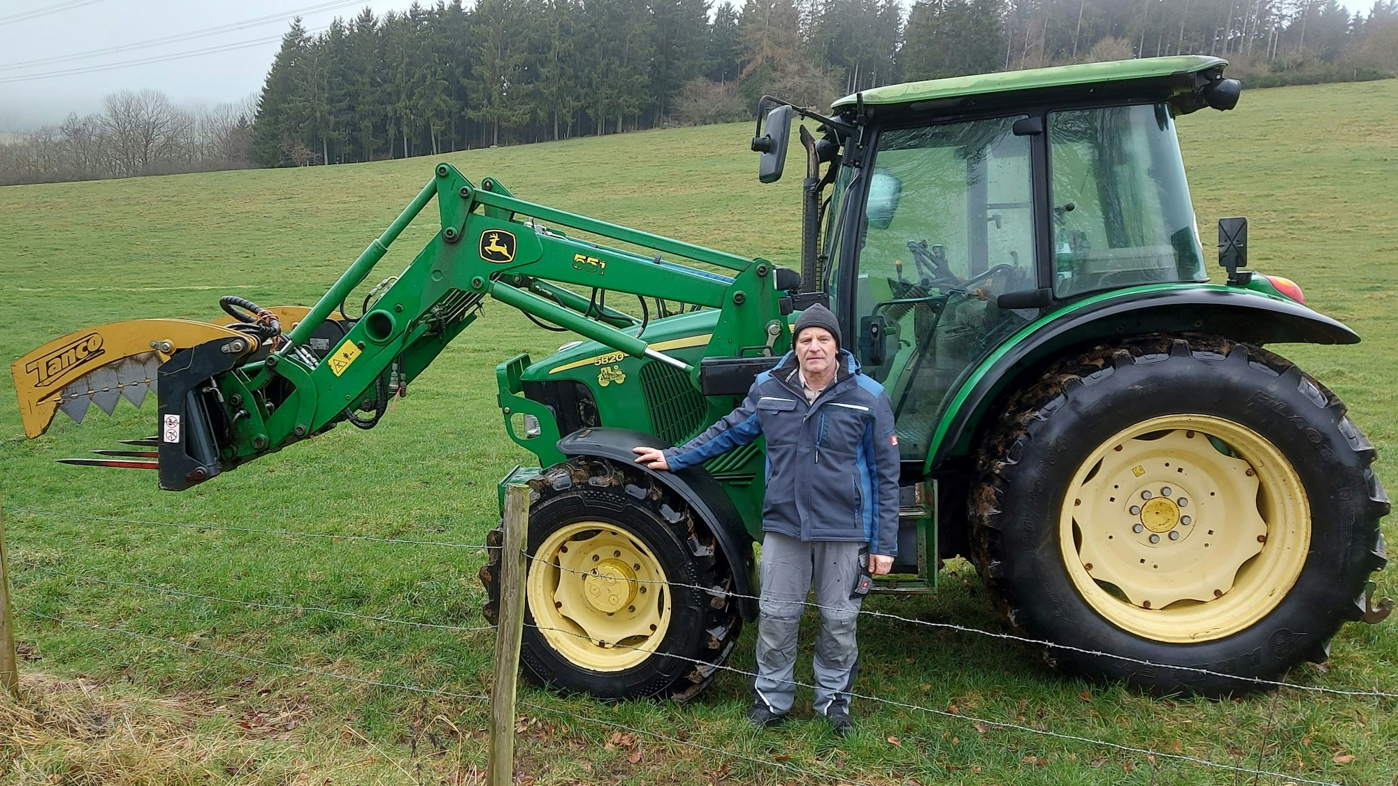 Der Baasemer Landwirt Johannes Nellessen steht neben einem seiner Traktoren auf einem Feld.