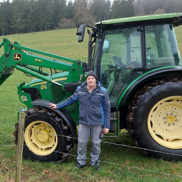 Der Baasemer Landwirt Johannes Nellessen steht neben einem seiner Traktoren auf einem Feld.