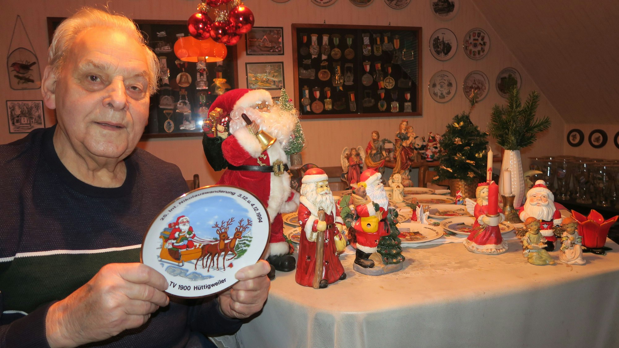 Ein Mann hält einen Teller mit einem Nikolaus, der in einem Rentierschlitten sitzt.