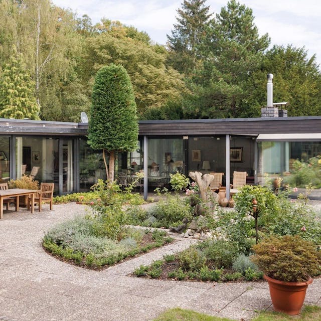 Ein L-förmiger Bungalow in Alt-Hahnwald mit großer Terasse und weitläufigen Garten steht für mehrere Millionen Euro zum Verkauf.