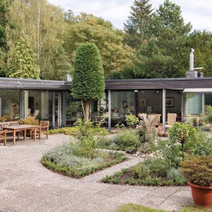 Ein L-förmiger Bungalow in Alt-Hahnwald mit großer Terasse und weitläufigen Garten steht für mehrere Millionen Euro zum Verkauf.