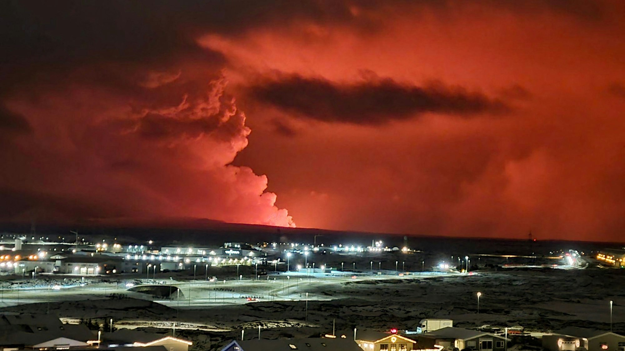 Vulkanausbruch auf Island: Häuser im isländischen Ort Hafnarfjordur wurden evakuiert, im Hintergrund sind die Rauchwolken zu sehen.