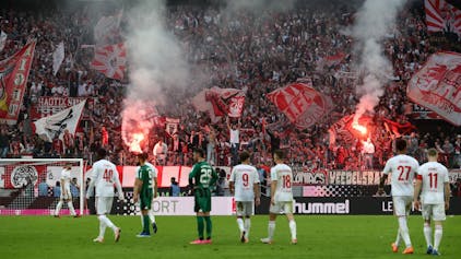 Während auf der Südtribüne des 1. FC Köln Bengalos brennen, wurde das Spiel gegen Borussia Mönchengladbach wegen Sichtbeeinträchtigung durch den erzeugten Rauch unterbrochen. Spieler beider Mannschaften stehen auf dem Rasen und betrachten das Treiben der Fans.&nbsp;
