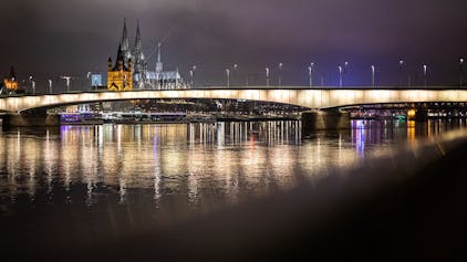 Das Panorama der Stadt Köln mit Kölner Dom und der Kirche Groß St. Martin ist hinter der Deutzer Brücke zu sehen.