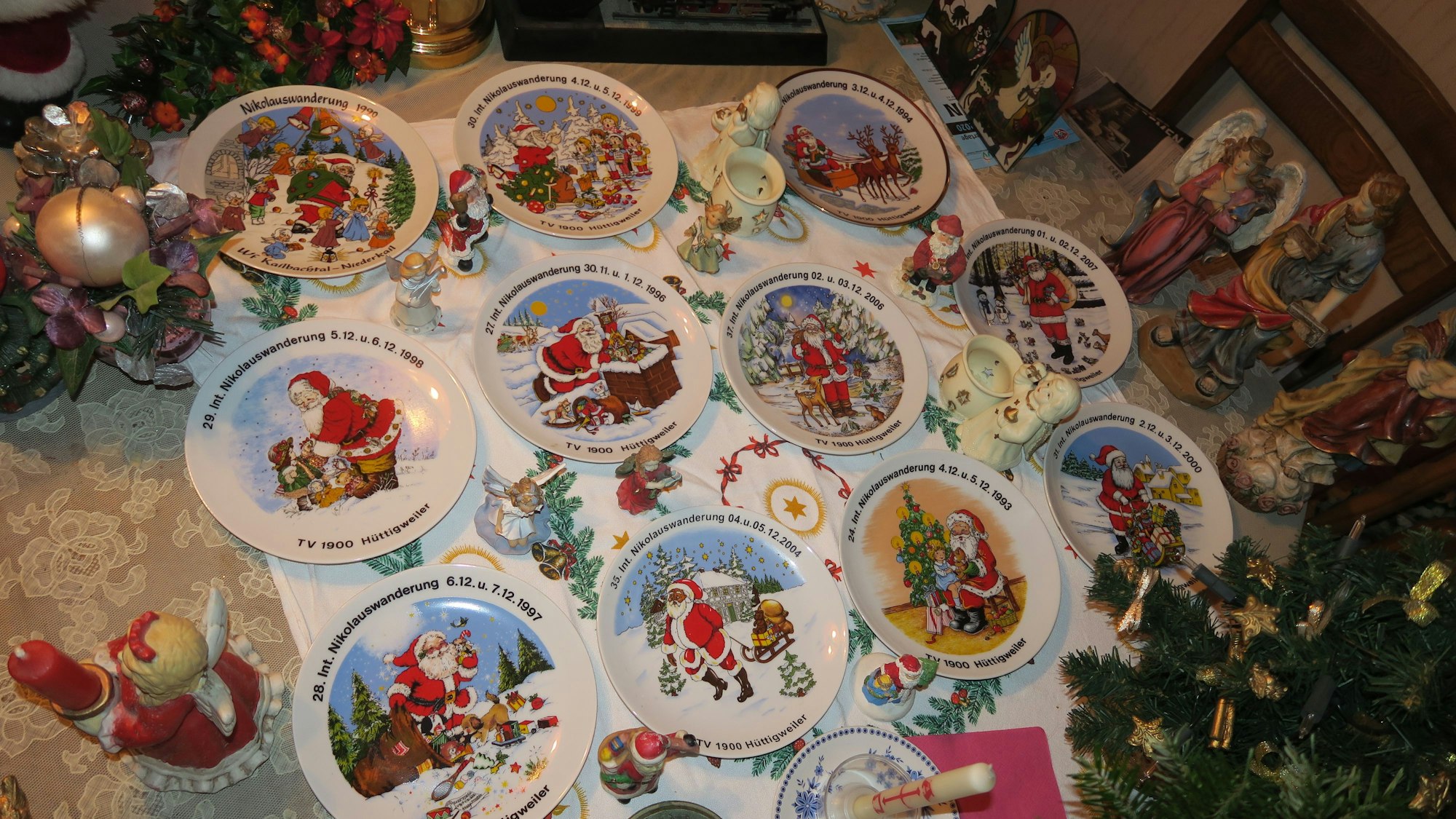 Krippenfiguren und Nikolausteller sind auf einem Tisch dekoriert.