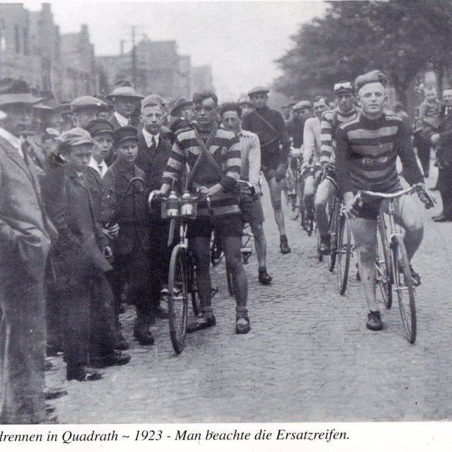 Ein altes Schwarz-Weiß-Foto zeigt ein Radrennen.