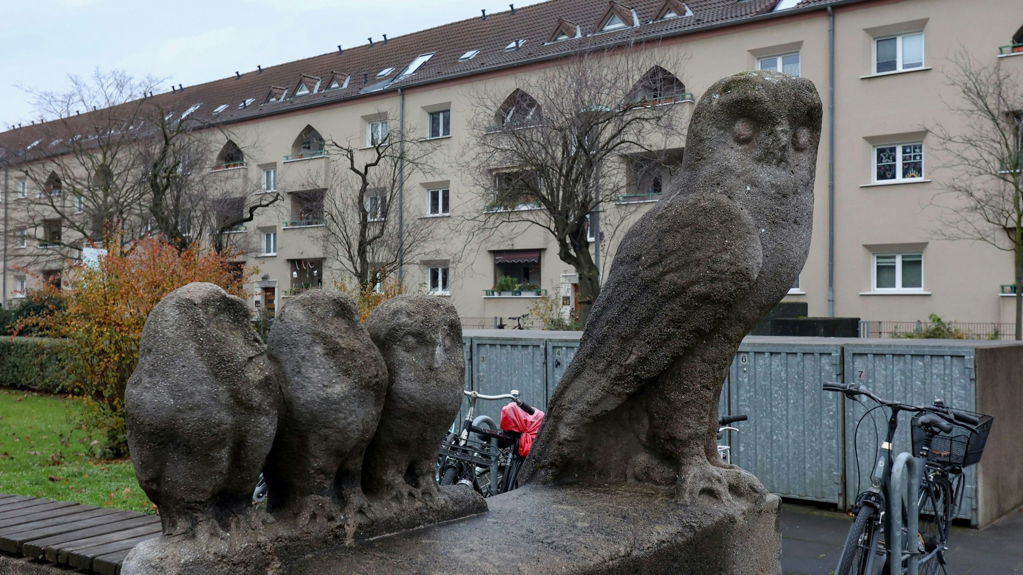 Eulenskulpturen vor einem Wohnhaus.
