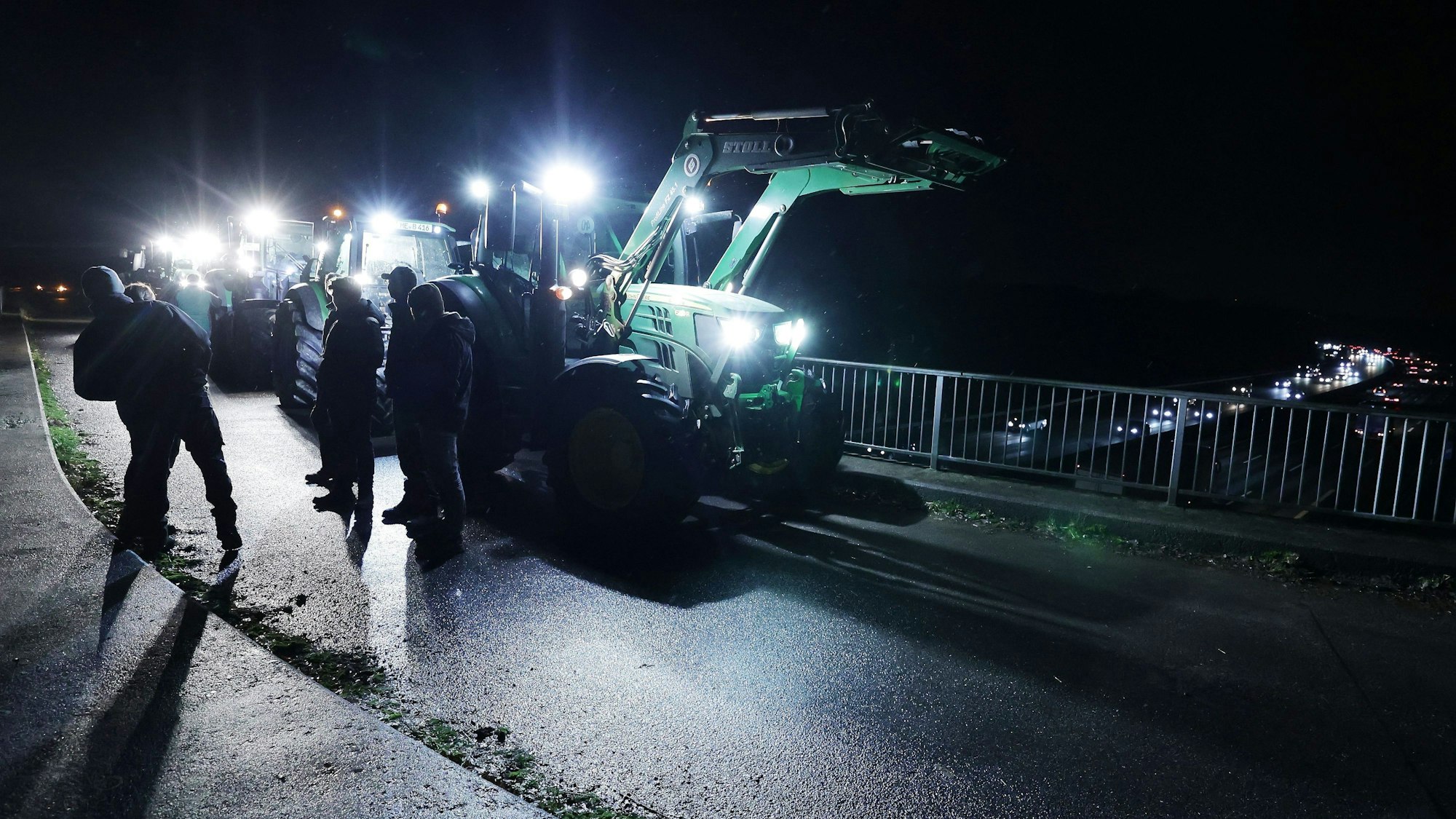 A3 bei Düsseldorf: Landwirte stehen mit Traktoren auf einer Brücke, um gegen die geplante Kürzung des Agrardiesels zu protestieren.