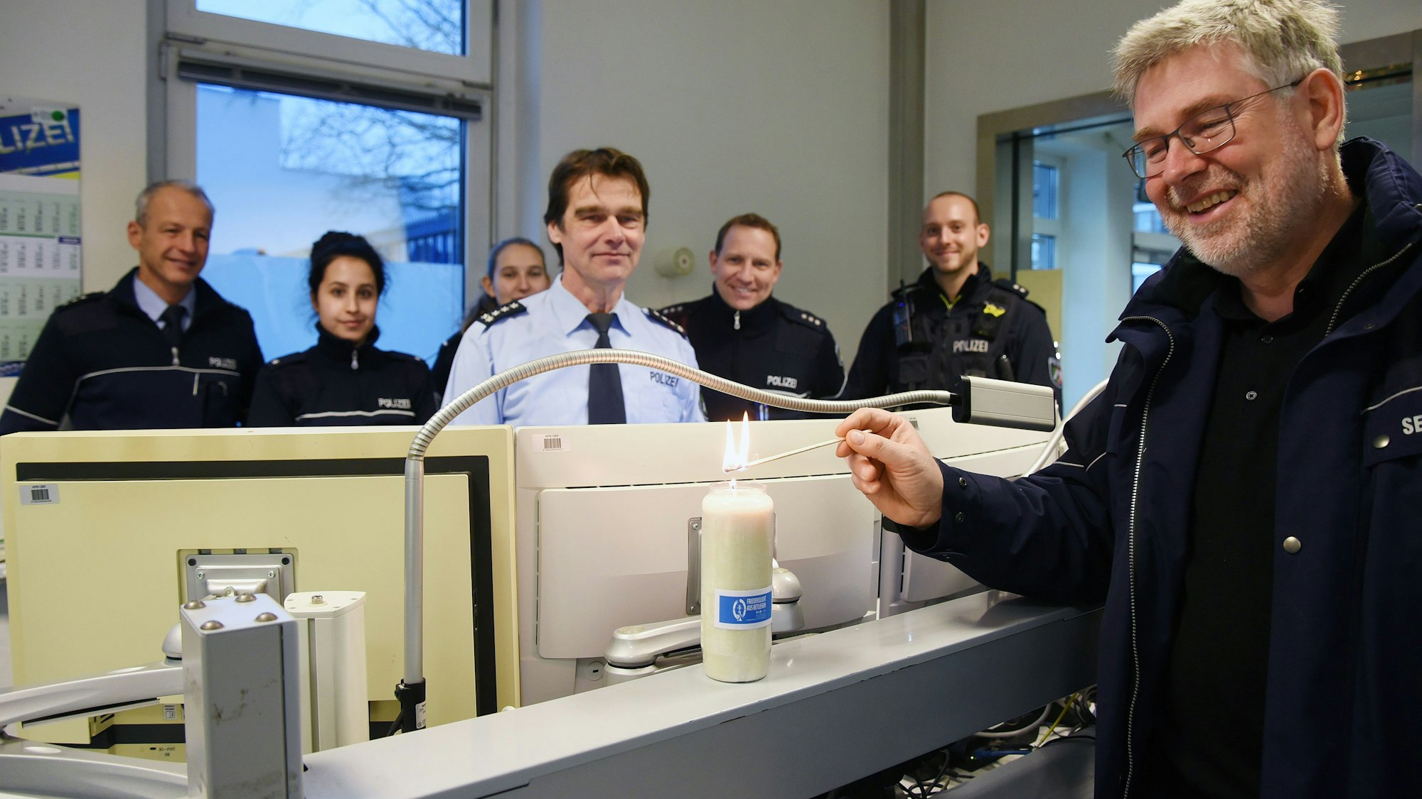 Polizeiseelsorger Norbert Schmitz von der Katholischen Polizeiseelsorge zündet das Licht in der Polizeiwache Wipperfürth an.